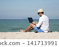 Man traveler use laptop on summer beach blue sky. Asian man casual blue short pants white shirt relax sitting summer beach. Man typing laptop computer holiday business trip freelance work on island 141713991