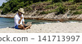 Banner Man traveler use laptop on summer beach blue sky. Asian man travel relax sitting summer beach island. Man typing laptop computer holiday business trip freelance working online with copy space 141713997