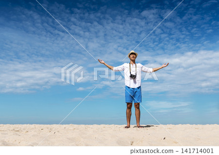 Man traveler using digital camera on summer beach blue sky take a photo. Asian Photographer man journey relax on the beach in summertime. Man backpack shooting photo asia destination holiday trip Man traveler using digital camera on summer beach blue sky take a photo. Asian Photographer man journey relax on the beach in summertime. Man backpack shooting photo asia destination holiday trip 141714001
