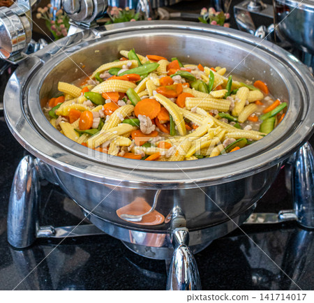 Fresh stir fried mixed vegetables featuring baby corn, carrots, snow peas and chicken served buffet style. Perfect for restaurant, catering, healthy food and hospitality concepts. Fresh stir fried mixed vegetables featuring baby corn, carrots, snow peas and chicken served buffet style. Perfect for restaurant, catering, healthy food and hospitality concepts. 141714017