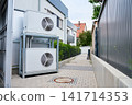 Outdoor heat pumps installed beside modern residential building 141714353