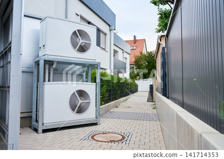 Outdoor heat pumps installed beside modern residential building Outdoor heat pumps installed beside modern residential building 141714353