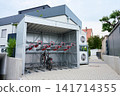 Covered bicycle parking with two level bike racks near modern building 141714355