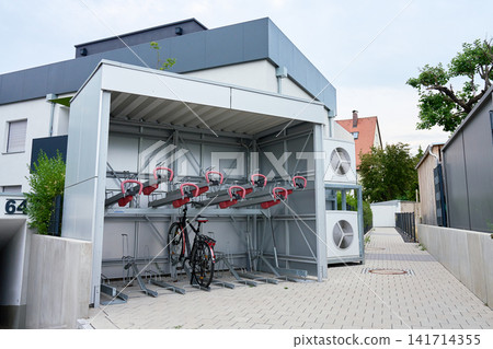 Covered bicycle parking with two level bike racks near modern building Covered bicycle parking with two level bike racks near modern building 141714355