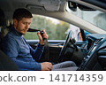 Man fastening seat belt before driving 141714359