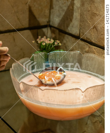 Creamy coconut milk dessert featuring colorful sago pearls served in a buffet glass bowl. Ideal for hospitality, restaurant, catering, travel, and culinary publishing. Creamy coconut milk dessert featuring colorful sago pearls served in a buffet glass bowl. Ideal for hospitality, restaurant, catering, travel, and culinary publishing. 141714873