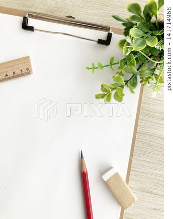 A natural desk background featuring a clipboard, stationery, and a houseplant. Perfect for studying or business. Includes a ruler and pencil. A natural desk background featuring a clipboard, stationery, and a houseplant. Perfect for studying or business. Includes a ruler and pencil. 141714968