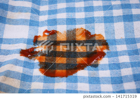 Stain on a checkered cloth in a kitchen setting Stain on a checkered cloth in a kitchen setting 141715319
