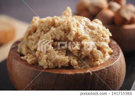 Nut butter served in a wooden bowl with nuts in background Nut butter served in a wooden bowl with nuts in background 141715368
