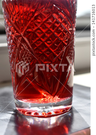 A crystal glass with red liquid. A crystal glass with red liquid. 141716013