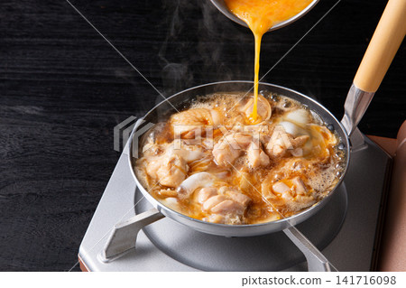 親子丼(雞肉雞蛋蓋飯)正在鍋中烹調(正在加入雞蛋) 親子丼(雞肉雞蛋蓋飯)正在鍋中烹調(正在加入雞蛋) 141716098