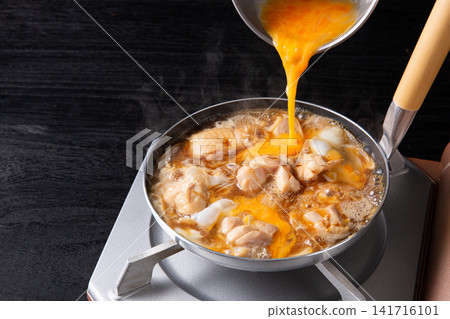Oyakodon (chicken and egg rice bowl) being cooked in a pot (egg being added) Oyakodon (chicken and egg rice bowl) being cooked in a pot (egg being added) 141716101