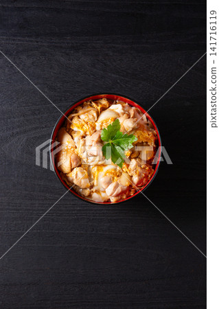 Oyakodon (chicken and egg rice bowl) on a black background Oyakodon (chicken and egg rice bowl) on a black background 141716119