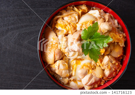 Oyakodon (chicken and egg rice bowl) on a black background Oyakodon (chicken and egg rice bowl) on a black background 141716123