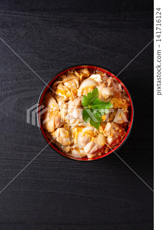 Oyakodon (chicken and egg rice bowl) on a black background Oyakodon (chicken and egg rice bowl) on a black background 141716124