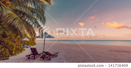 Romantic beach loungers under palm-fringed umbrella at pastel sunset on powder-white sand tropical shore. Perfect summer vacation travel landscape paradise. Luxury honeymoon getaway relax scenic Romantic beach loungers under palm-fringed umbrella at pastel sunset on powder-white sand tropical shore. Perfect summer vacation travel landscape paradise. Luxury honeymoon getaway relax scenic 141716409