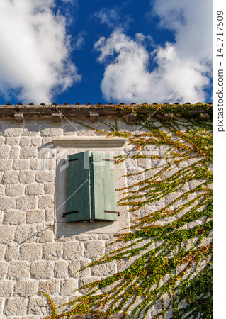 Window with wooden shutters in a Mediterranean-style house Window with wooden shutters in a Mediterranean-style house 141717509
