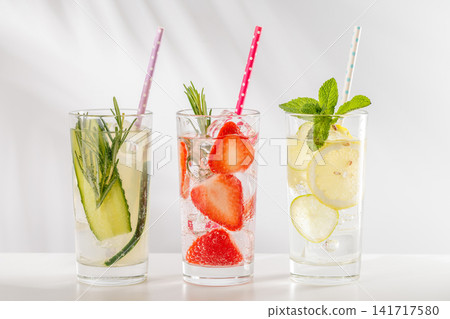 Set of fresh non alcoholic drinks with strawberry cucumber and lemon on white background Set of fresh non alcoholic drinks with strawberry cucumber and lemon on white background 141717580