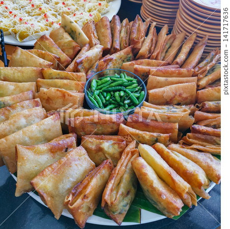 Close up of martabak mini fried snacks with chili. Indonesian street food, crispy texture, authentic Asian cuisine and sharing food concept. Close up of martabak mini fried snacks with chili. Indonesian street food, crispy texture, authentic Asian cuisine and sharing food concept. 141717636