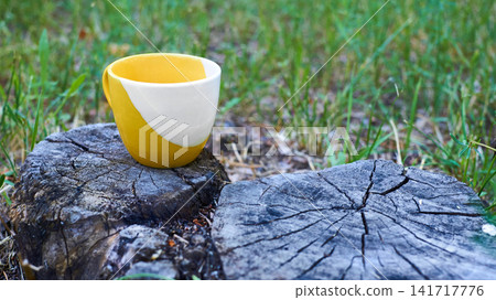 Coffee break tea time.Yellow cup on tree stump Coffee break tea time.Yellow cup on tree stump 141717776