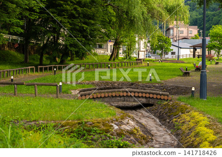 The scenery of the park and stream in the lush green Onogawa Onsen town. 141718426