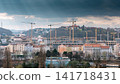 Prague urban skyline with large construction cranes and modern development beneath dramatic storm clouds, showing rapid city growth and changing architecture in Prague City Czech Republic 141718431