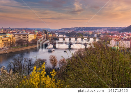 Panoramic Prague cityscape with Vltava River and historic bridges at sunset, showcasing colorful spring scenery, European architecture and the romantic skyline of Prague City Czech Republic Panoramic Prague cityscape with Vltava River and historic bridges at sunset, showcasing colorful spring scenery, European architecture and the romantic skyline of Prague City Czech Republic 141718433