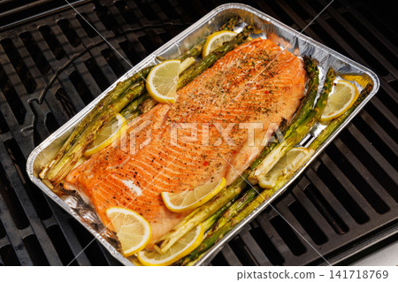 Grilled salmon fillets and asparagus sizzling on a barbecue grill Grilled salmon fillets and asparagus sizzling on a barbecue grill 141718769