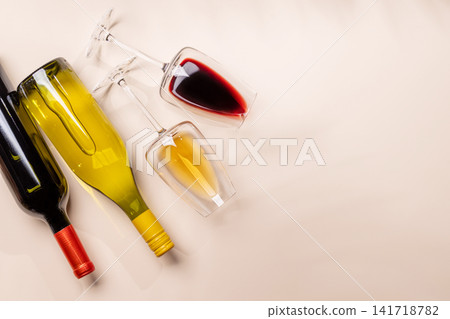 Wine glasses with red and white wine lying on beige background Wine glasses with red and white wine lying on beige background 141718782