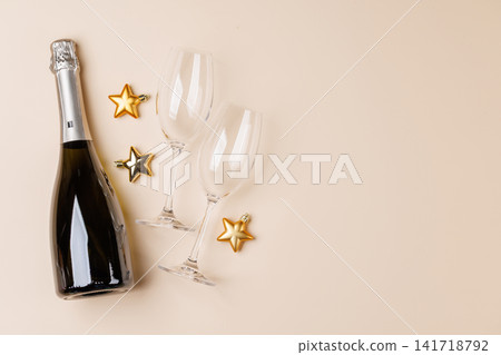 Champagne bottle and glasses on beige background Champagne bottle and glasses on beige background 141718792