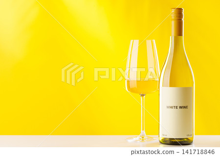 White wine bottle and glass on yellow background elegant drink setup White wine bottle and glass on yellow background elegant drink setup 141718846