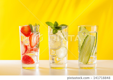 Set of fresh non alcoholic drinks with strawberry cucumber and lemon on yellow background Set of fresh non alcoholic drinks with strawberry cucumber and lemon on yellow background 141718848