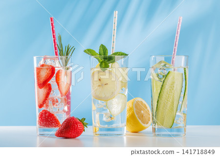 Set of fresh non alcoholic drinks with strawberry cucumber and lemon on blue background Set of fresh non alcoholic drinks with strawberry cucumber and lemon on blue background 141718849