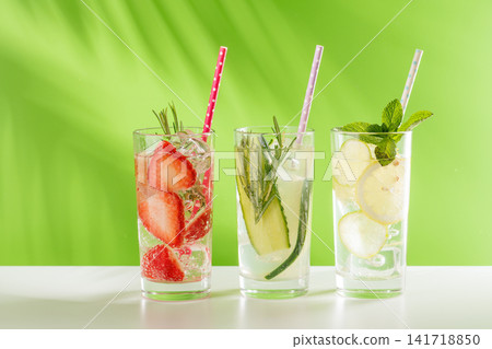 Set of fresh non alcoholic drinks with strawberry cucumber and lemon on green background Set of fresh non alcoholic drinks with strawberry cucumber and lemon on green background 141718850