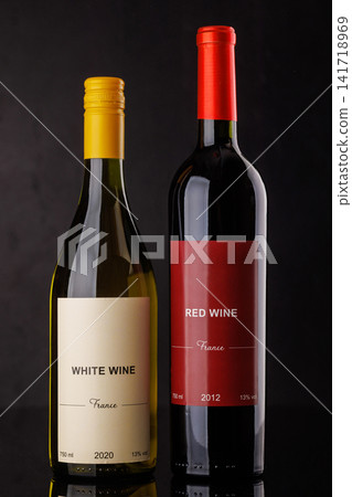 Red and white wine bottles on dark background 141718969