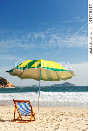 Beach loungers and umbrella by the sea Beach loungers and umbrella by the sea 141719117