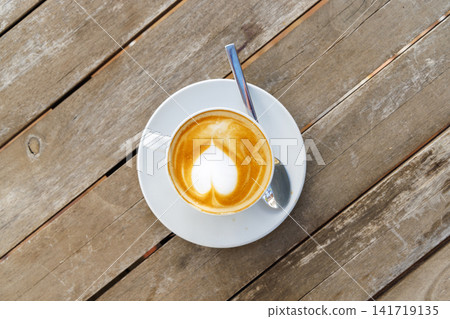 Cappuccino with heart foam on wooden table Cappuccino with heart foam on wooden table 141719135