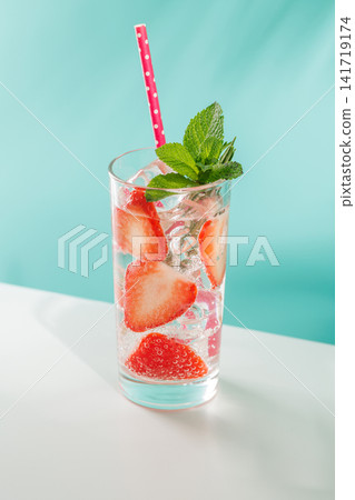 Fresh strawberry infused water with herbs on blue background with copy space Fresh strawberry infused water with herbs on blue background with copy space 141719174