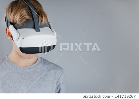Boy with White VR Glasses and Gamepads Diving into Immersive Virtual Reality Adventure on Plain Free space Boy with White VR Glasses and Gamepads Diving into Immersive Virtual Reality Adventure on Plain Free space 141719267