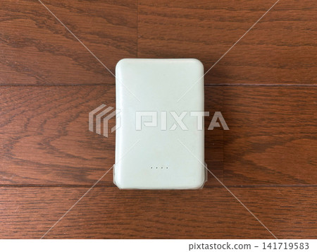 從正上方俯視的手機電池；木地板上的手機充電器。 141719583
