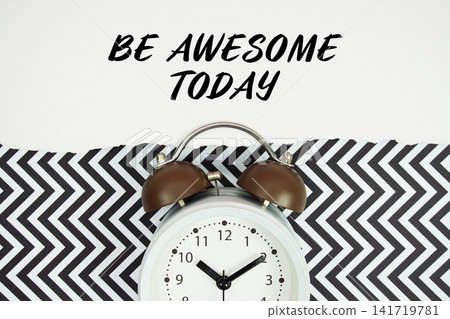 Be Awesome Today text written on paper with alarm clock on black chevron background 141719781