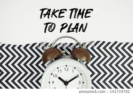 Take Time To Plan text written on paper with alarm clock on black chevron background 141719782