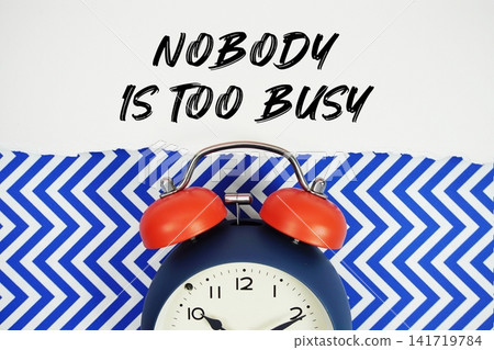 Nobody Is Too Busy text written on paper with alarm clock on blue chevron background 141719784