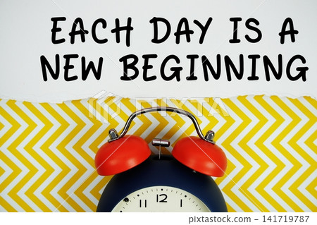 Each Day Is A New Beginning text written on paper with alarm clock on yellow chevron background 141719787