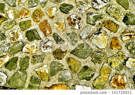 A cobblestone texture background made of irregularly shaped green and ochre stones. A cobblestone texture background made of irregularly shaped green and ochre stones. 141720051