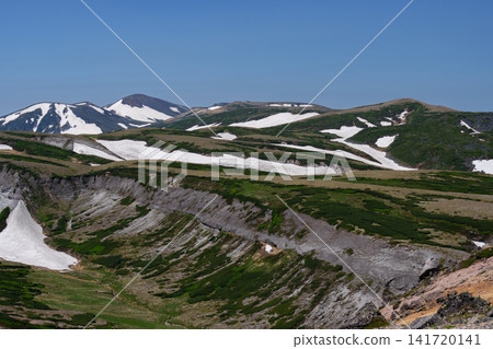 令人驚嘆的夏日景色:北海道大雪山山脈,從赤岳到白雲山的山脊小徑被白雪覆蓋。 令人驚嘆的夏日景色:北海道大雪山山脈,從赤岳到白雲山的山脊小徑被白雪覆蓋。 141720141