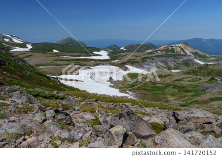 令人驚嘆的夏日景色:北海道大雪山山脈,從赤岳到白雲山的山脊小徑被白雪覆蓋。 令人驚嘆的夏日景色:北海道大雪山山脈,從赤岳到白雲山的山脊小徑被白雪覆蓋。 141720152