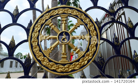 Golden Dharmachakra Wheel of Dhamma Symbol on Wrought Iron Fence Golden Dharmachakra Wheel of Dhamma Symbol on Wrought Iron Fence 141720164