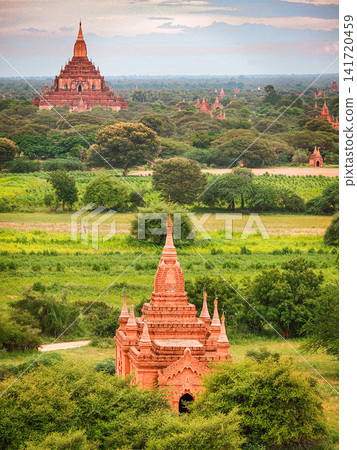 Ancient Bagan temple pagodas rising above the green plains of Myanmar, a UNESCO World Heritage landscape with red brick stupas and layered countryside views Ancient Bagan temple pagodas rising above the green plains of Myanmar, a UNESCO World Heritage landscape with red brick stupas and layered countryside views 141720459