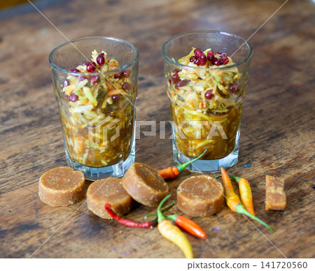 Rujak serut fruit salad with pomegranate, shredded fruits, and spicy palm sugar sauce served in glass cups. Indonesian traditional cuisine. Rujak serut fruit salad with pomegranate, shredded fruits, and spicy palm sugar sauce served in glass cups. Indonesian traditional cuisine. 141720560